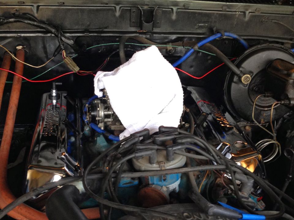 Close-up of a V8 engine with chrome valve covers, carburetor, and wiring.