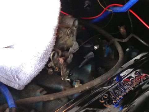 1979 Ford Bronco - A close-up view of a carburetor and engine components in a vehicle, with various wires and hoses visible. A shiny chrome part with "Edelbro…