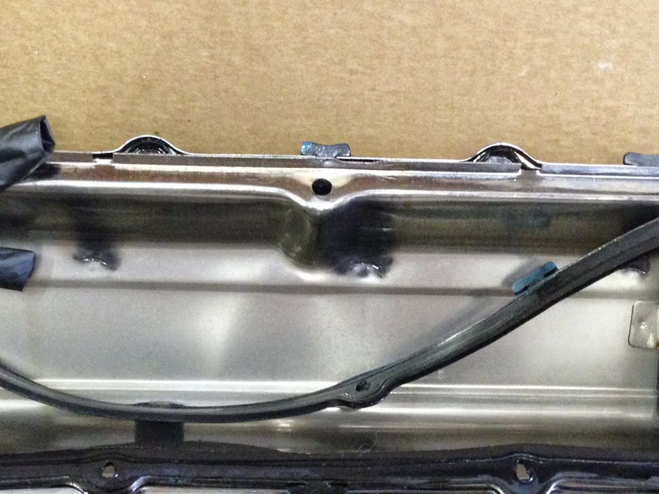 Inside of a metal valve cover with black rubber gasket.