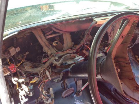 1979 Ford Bronco - The interior of a 1979 Ford Bronco shows a disassembled dashboard with exposed wiring and the steering column. The steering wheel is visibl…
