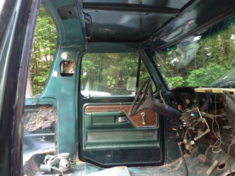 1979 Ford Bronco - Interior view of a classic green Ford Bronco under restoration. The dashboard is partially disassembled, revealing wiring and components, w…