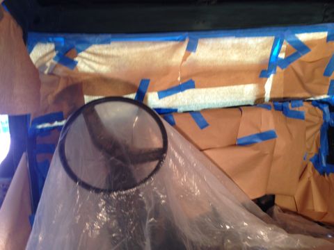 1979 Ford Bronco - This image shows the interior of a vehicle that is being prepped for painting. Brown paper and blue painter's tape are used to mask off are…