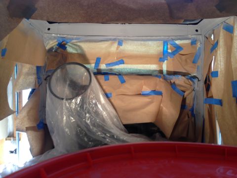 1979 Ford Bronco - This image shows the interior of a vehicle that is being prepped for painting. Brown paper and blue painter's tape are used to mask off are…