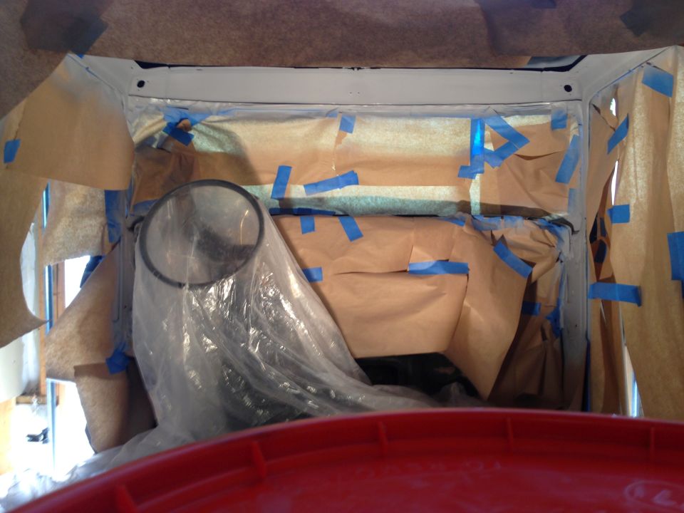 Interior of a vehicle being prepped for painting with masking paper and tape.