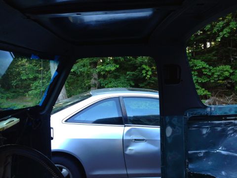 1979 Ford Bronco - View from inside a vehicle looking out at a silver sedan with significant body damage on its passenger side door. The interior of the vehic…
