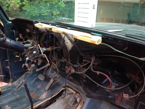 1979 Ford Bronco - The interior of a dismantled 1979 Ford Bronco dashboard shows exposed wiring, steering column, and pedals. The dashboard trim has been remo…
