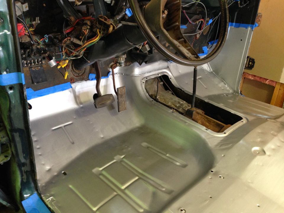 Interior of a classic vehicle with new metal floor pan, dashboard wiring, and pedals.