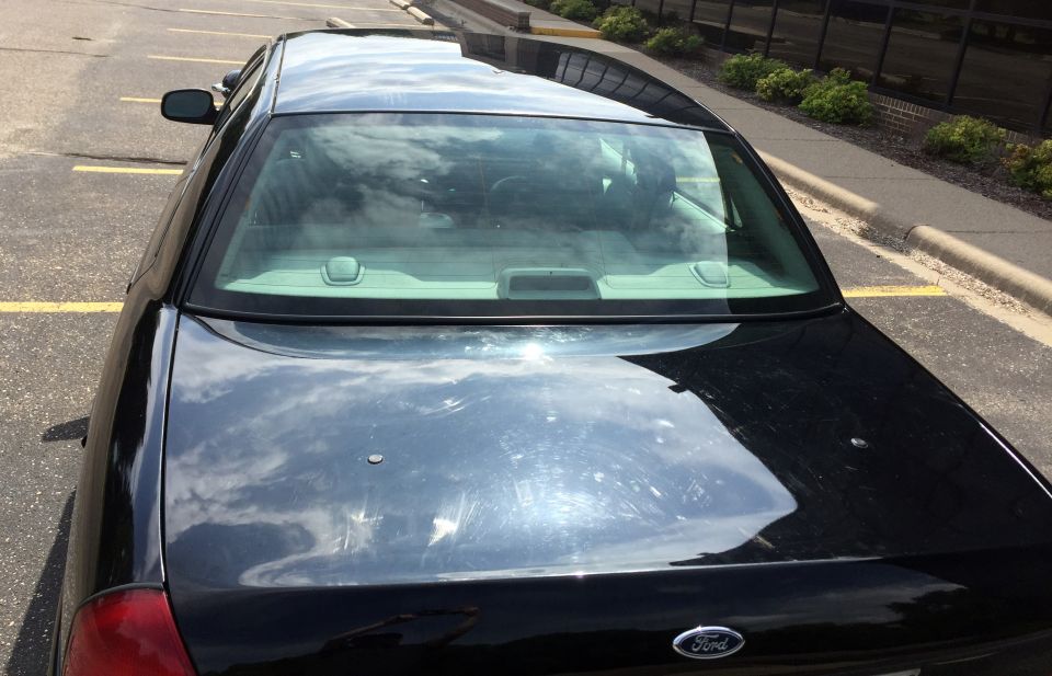 Black 2007 Ford Crown Victoria sedan, rear view, parked in a lot.