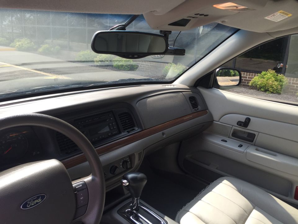 Interior of a Ford Crown Victoria, showing dashboard, steering wheel, and door panel.
