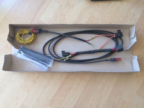 1997 Dodge 3500 - A wiring harness with multiple connectors and a coil of yellow wire is laid out inside a cardboard box on a wooden floor.