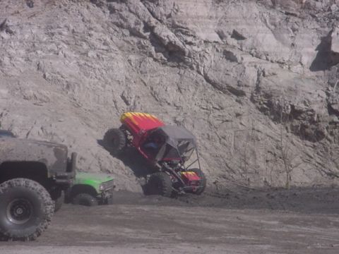 1988 Ford Bronco - An off-road buggy navigates a steep, muddy terrain, with other vehicles visible in the scene.