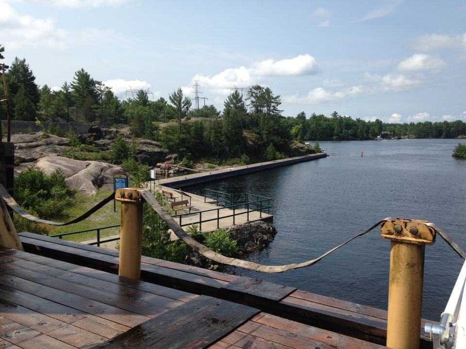 Wooden dock and pier on a lake with trees and rocky shores.