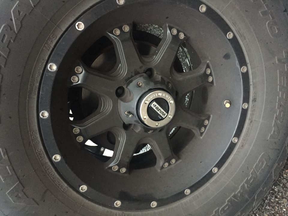 Close-up of a black aftermarket wheel with a WARN locking hub.