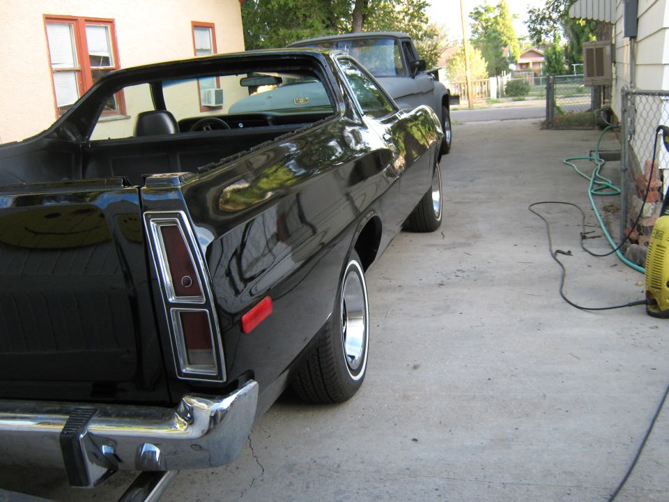 Black 1973 Ford Ranchero rear driver's side view in a driveway.