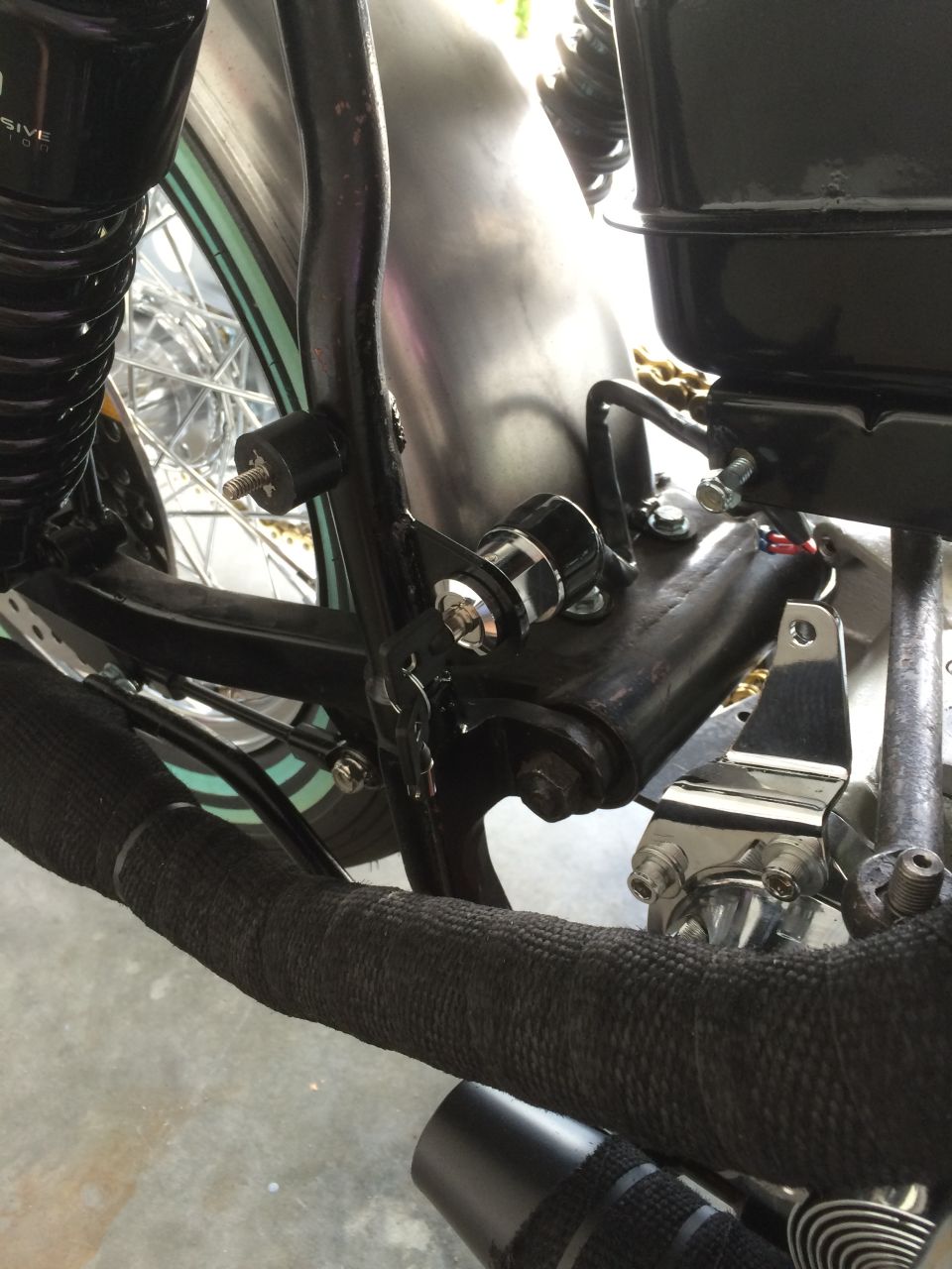 Motorcycle frame detail with ignition switch and black exhaust wrap