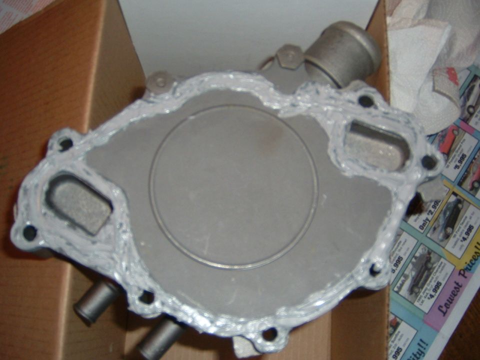 Water pump with gasket sealant applied, showing ports and mounting holes