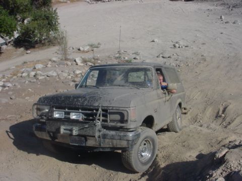 1988 Ford Bronco - 1988 Ford Bronco navigating a rough, rocky terrain.