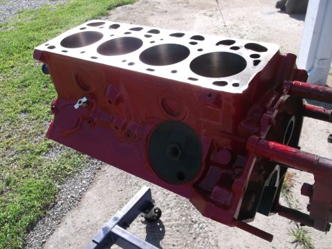 1957 Ford Custom Sedan - A red engine block is mounted on a stand, ready for assembly or inspection. The image focuses on the engine block's internal structure and…