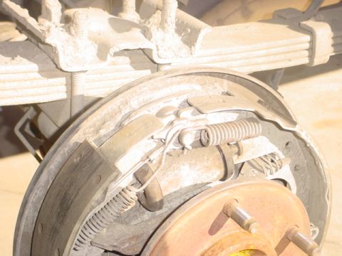 1988 Ford Bronco - Close-up of a vehicle's rear drum brake assembly, showing brake shoes and springs.
