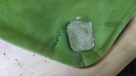 1992 Ford Bronco - Close-up of a green headliner section with a cutout showing the interior material.