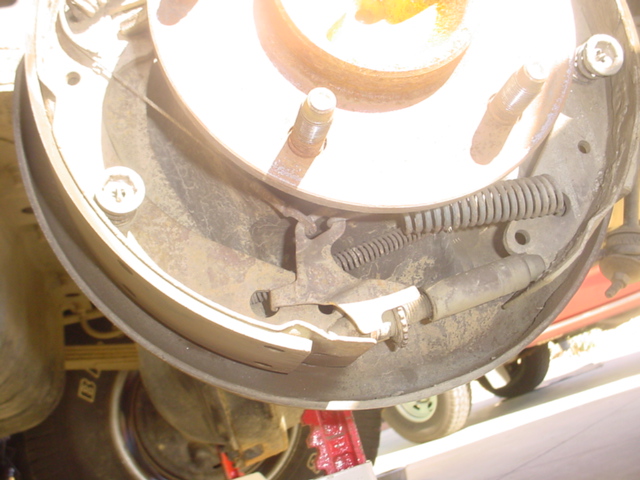 Rear drum brake backing plate with shoes, springs and wheel cylinder, drum removed