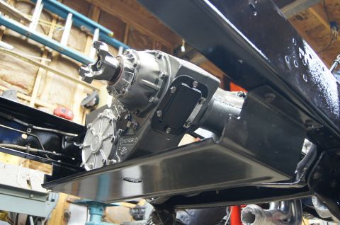 1979 Ford Bronco - A close-up, low-angle view of a transfer case and part of a vehicle's frame, likely during a restoration or build.