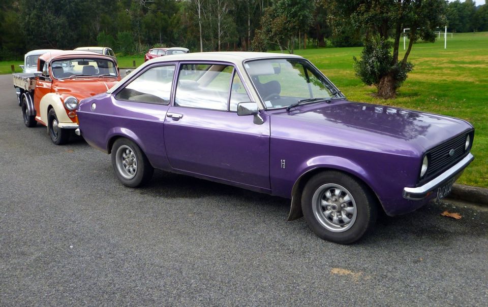 Purple two-door coupe with white roof, parked on asphalt.