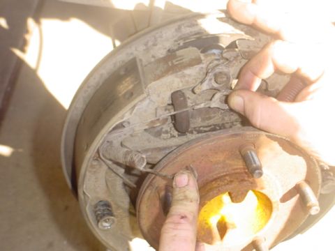 1988 Ford Bronco - Close-up of a vehicle's rear brake drum assembly being serviced.