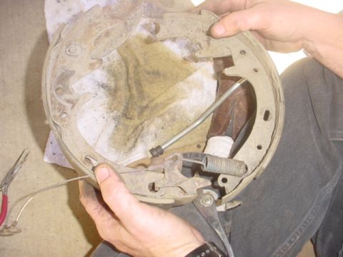 1988 Ford Bronco - Close-up of a vehicle's brake drum assembly being worked on, showing internal components.