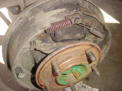 1988 Ford Bronco - Drum brake assembly showing wear and rust on a vehicle's wheel hub.