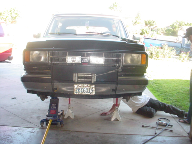 Black Ford Bronco on jack stands, front end visible, with a winch and aftermarket bumper