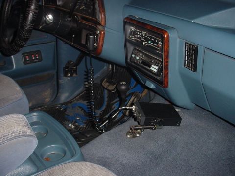 1988 Ford Bronco - The interior of a truck shows the dashboard, steering wheel, and passenger seat, with a CB radio installed.