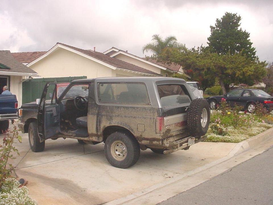 1988 Ford Bronco parked in a driveway with doors open, spare tire mounted on rear