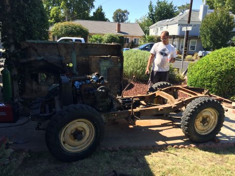 1946 Jeep Willys - A man stands next to a heavily rusted Jeep CJ5 chassis and body tub during a restoration project. A welding machine and gas cylinder are vi…