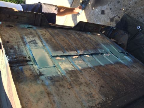 1946 Jeep Willys - This is a close-up, overhead view of the underside of a heavily rusted vehicle floor pan. Patches of green primer are visible, along with a…