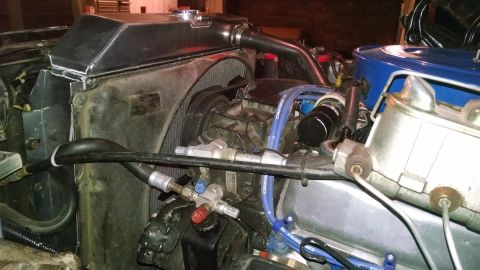 1979 Ford F-150 - The engine bay of a vehicle shows a custom aluminum radiator and fan assembly. Visible components include the master cylinder, air conditio…