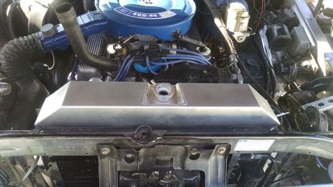 1979 Ford F-150 - A close-up view of the engine bay of a 1979 Ford F-150, focusing on the new aluminum radiator and the blue air cleaner assembly.