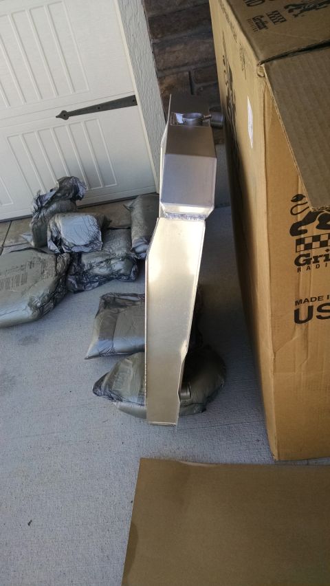 1979 Ford F-150 - A new aluminum radiator is shown next to a large cardboard box and several silver-wrapped packages on a concrete driveway.