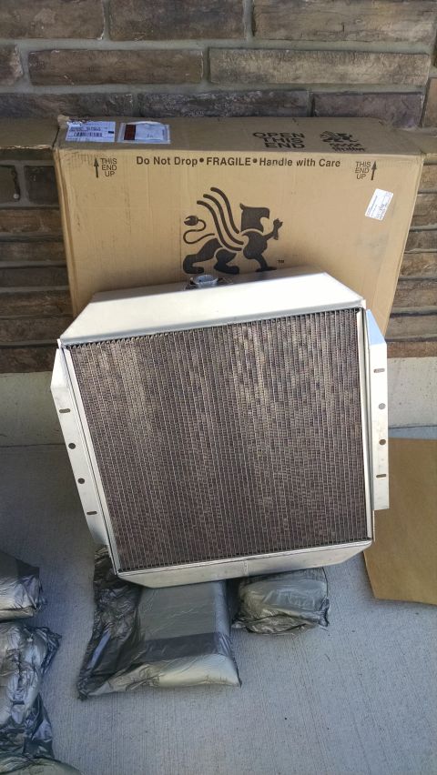 1979 Ford F-150 - A new aluminum radiator is shown in front of its cardboard shipping box. The radiator is supported by several wrapped bundles on a concrete…