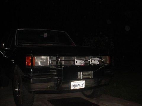 1988 Ford Bronco - Front view of a black truck equipped with Hella lights and a winch, with a license plate reading "HEAVY".