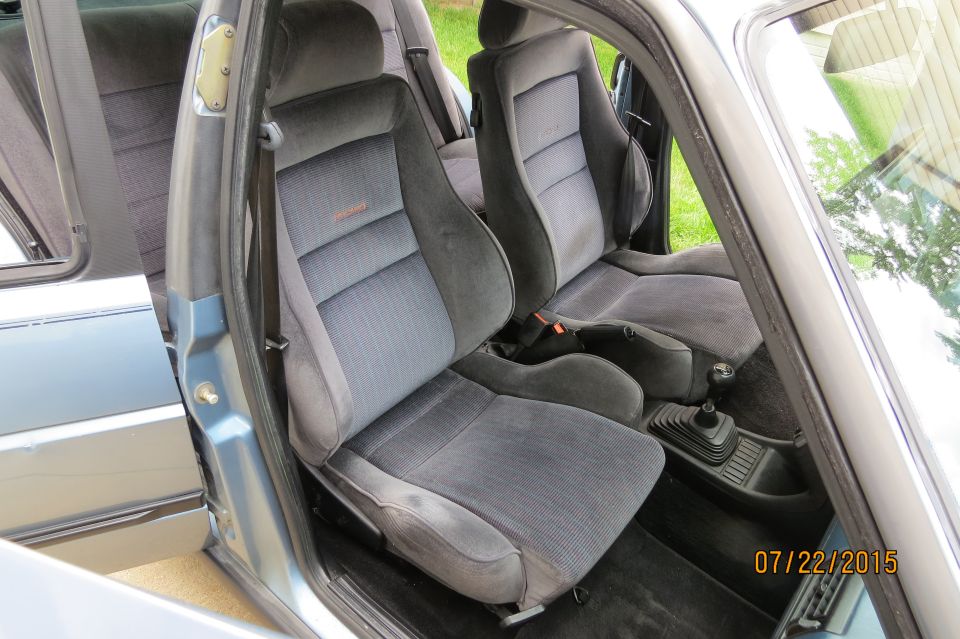 Interior of a blue 1990 Volkswagen Jetta showing front seats and gear shifter.
