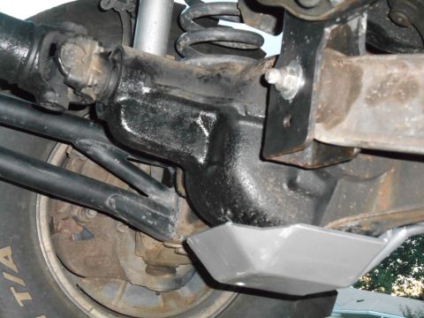 1994 Ford Bronco - Underside view of a 1994 Ford Bronco's rear differential housing, showing the driveshaft connection and a protective skid plate. The suspen…
