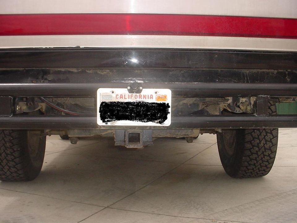 Rear view of an SUV with a California license plate and a trailer hitch