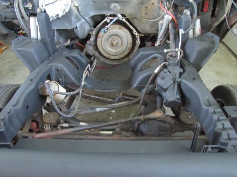 1995 Ford Bronco - This is a close-up, low-angle shot of the chassis and engine components of a vehicle, likely a 1995 Ford Bronco, during a restoration or mo…