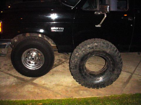 1988 Ford Bronco - Comparing a mounted tire with a new off-road tire next to a 1988 Ford Bronco.