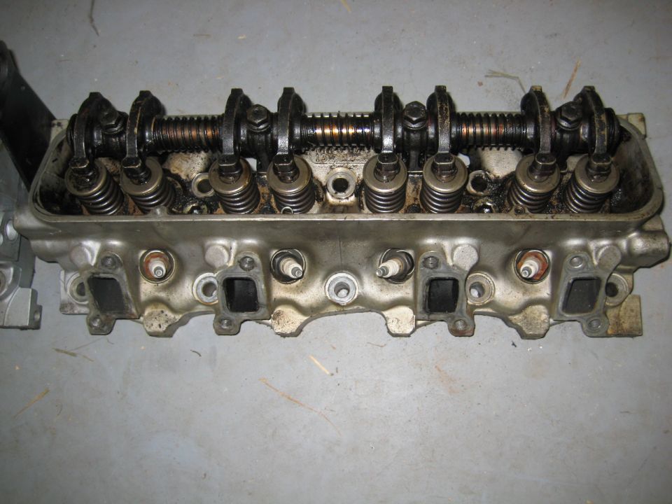 V8 engine cylinder head with rocker arms, valves, and spark plugs