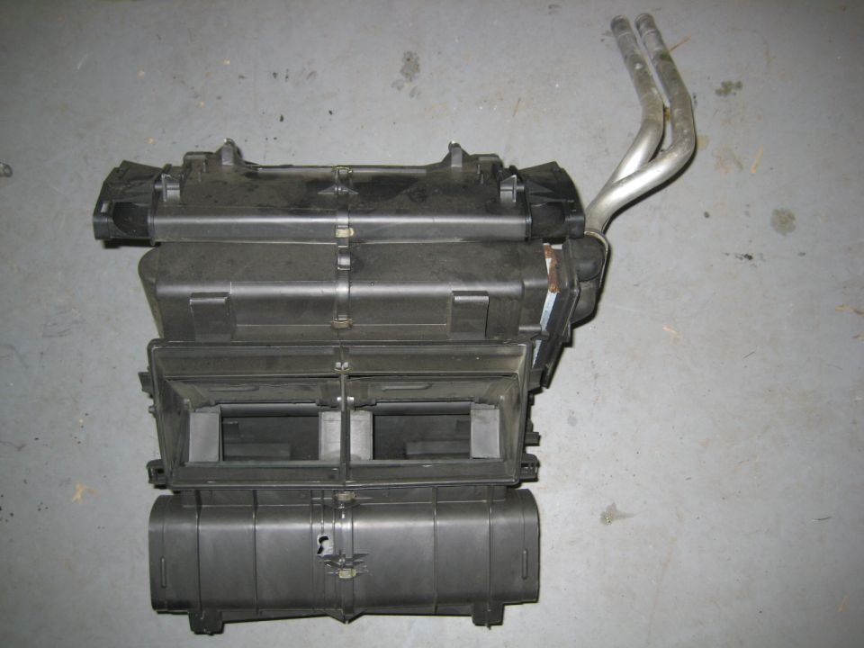 Black automotive HVAC assembly with metal tubes