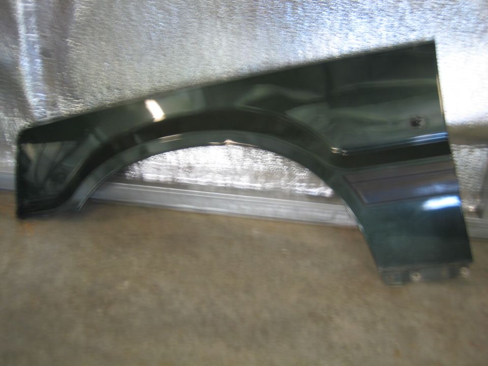 Dark green vehicle fender with curved wheel well