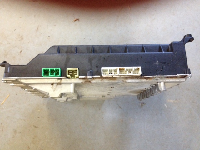 Black electronic control unit with silver top and multiple connectors.