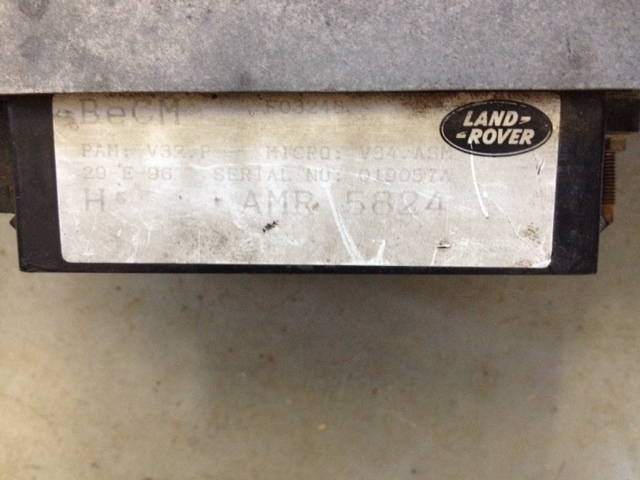 Land Rover BeCM unit label with serial number AMR 5824 and Land Rover logo.